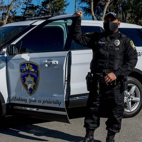 A Security Guard of VP Security Services Standing Beside Company's Car in San Jose