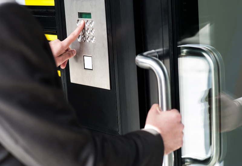 Person in formal attire pressing a door button for access control in San Jose, CA.